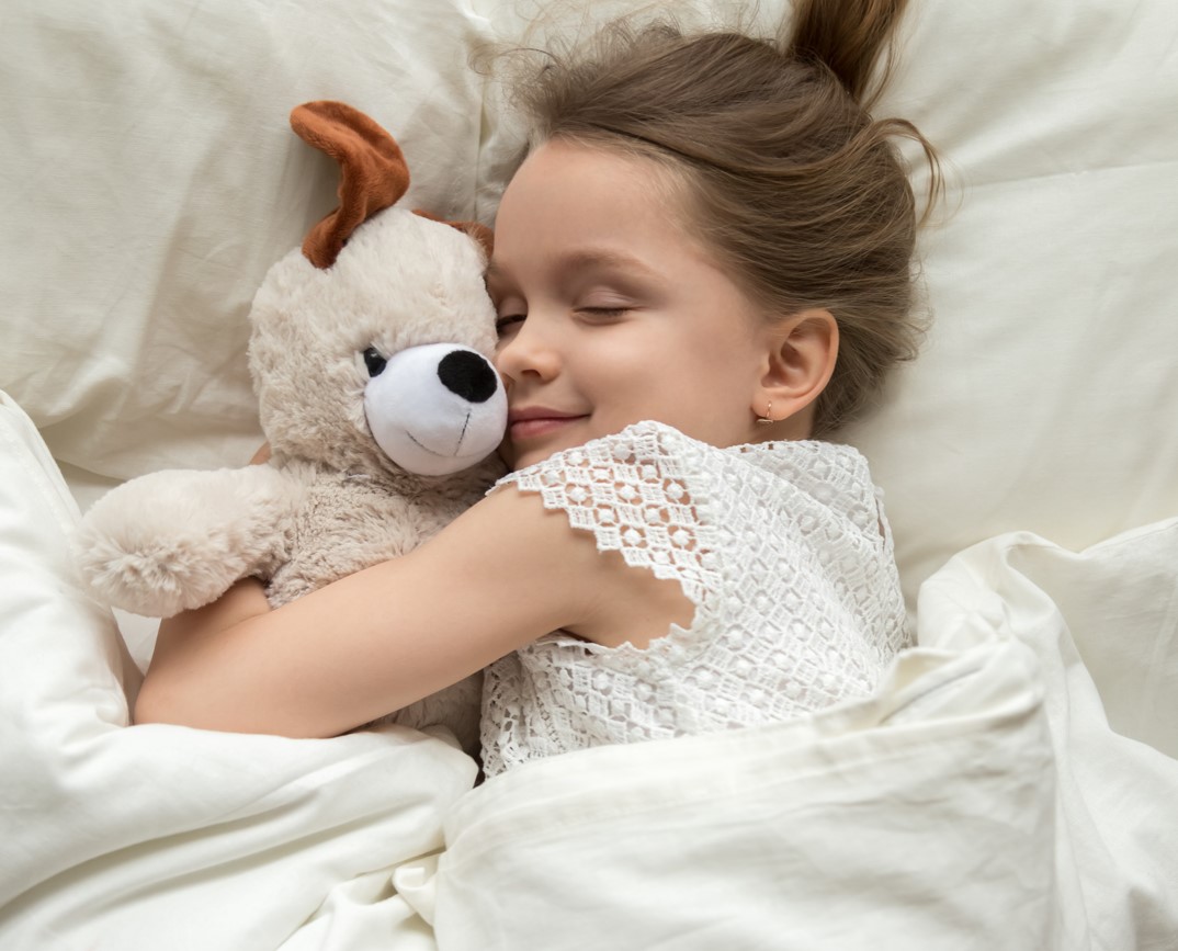 Girl sleeps with a teddy bear