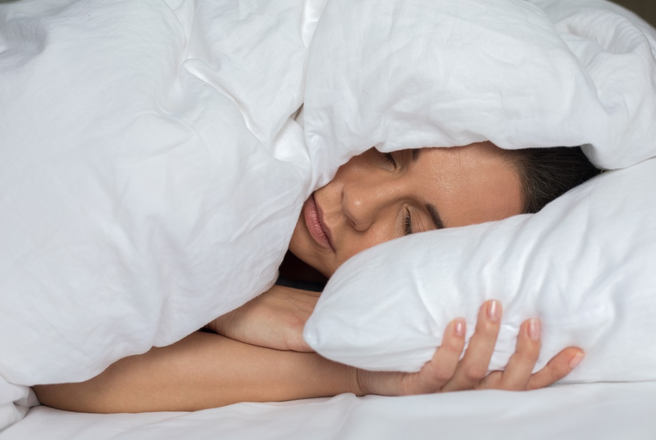 Woman sleeping in bed under the blanket