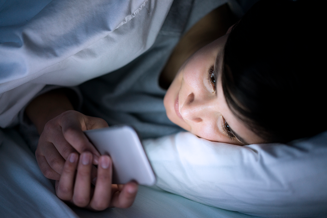 Woman looking at the phone in bed