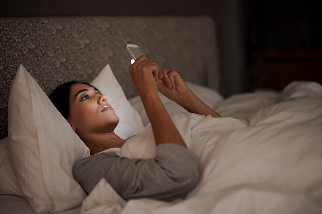 Woman looking at the phone in bed